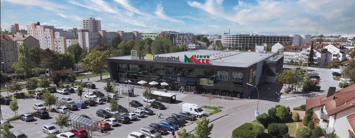 Luftaufnahme des EDEKA Braun Centers: das langgestreckte Gebäude mit Parkplatz und Tankstelle von oben.